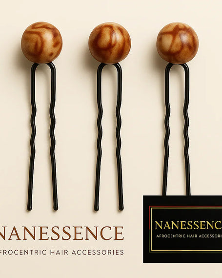 Set of three Afrocentric hair pins with decorative brown round wooden tops on light background