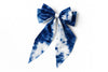 Handcrafted blue and white tie-dye fabric bow accessory on white background