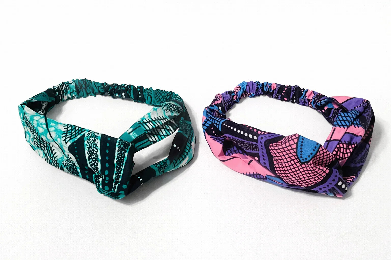 Two Afrocentric headbands with vibrant blue and pink Ankara prints on a white background
