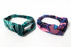 Two Afrocentric headbands with vibrant blue and pink Ankara prints on a white background