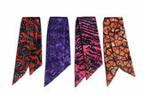 Four Afrocentric satin scarves in vibrant red, purple, pink, and orange with bold patterns