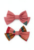 Two handcrafted pink Afrocentric bow ties, one with multicolored and gold accents, on white background