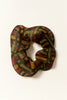 Afrocentric patterned scrunchie in red, yellow, and green on neutral background