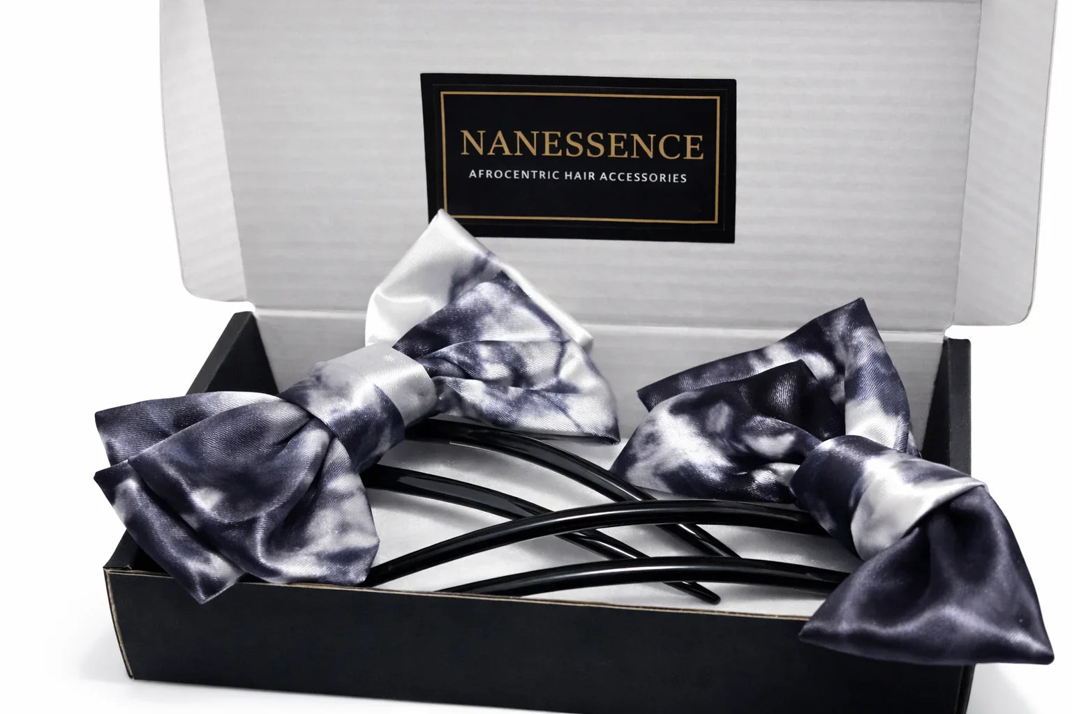 Box with two Afrocentric satin hair bows in black and white tie-dye pattern.