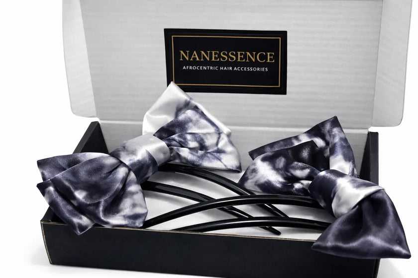 Box with two Afrocentric satin hair bows in black and white tie-dye pattern.