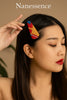 Woman with sleek hair wearing a colorful Afrocentric patterned hair clip