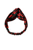 Red and black Afrocentric patterned fabric headband with elastic band on white background