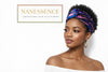 Woman wearing a vibrant blue and purple Afrocentric headwrap and gold hoop earrings