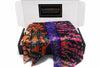 Box of Afrocentric satin hair accessories with vibrant patterns in orange, purple, and pink.