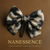Afrocentric black and beige patterned bow hair clip on brown background, elegant accessory
