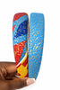 Hand holding two Afrocentric headbands with vibrant blue, red, yellow, and gold patterns