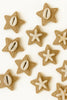 Star-shaped textured earrings with cowrie shells and starfish accents on a white background