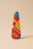 Handcrafted Afrocentric hair clip with bold red, yellow, and blue geometric pattern on beige background
