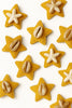 Yellow star-shaped handcrafted accessories with cowrie shells and starfish accents on white background