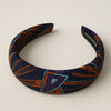 Afrocentric padded headband with geometric orange, blue, and purple patterns on fabric.