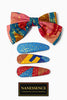 Colorful Afrocentric hair bow and three patterned hair clips with gold accents on white background.