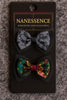 Set of two Afrocentric bow hair clips, one in gray tie-dye and one in colorful batik style, on display card