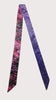 Handcrafted Afrocentric satin scarf with purple and pink batik pattern, isolated on white background.