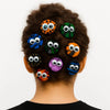 Woman with curly hair decorated with colorful Afrocentric hair accessories featuring quirky eyes.