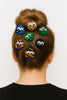 Woman with hair bun decorated by colorful Afrocentric fabric hairpins with googly eyes