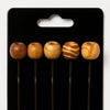 Set of five handcrafted wooden hair sticks with natural patterns on a display card
