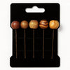 Handcrafted wooden hairpins with Afrocentric designs on a black display card