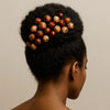 Afrocentric updo hairstyle adorned with natural wooden beads, showcasing cultural elegance.