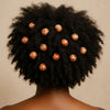 Back view of a person with natural afro hair styled with large brown wooden beads.