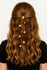 Handcrafted Afrocentric hair accessories with beaded ornaments in brown wavy hair