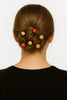 Elegant low bun hairstyle adorned with wooden and red decorative hair beads