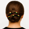 Woman with braided bun hairstyle adorned with colorful Afrocentric hairpins on white background