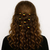Woman with wavy hair wearing Afrocentric beaded hair accessories in red, yellow, and green.