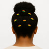 Afro bun hairstyle adorned with round hair accessories in red, yellow, green stripes