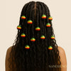 Woman with braided Afrocentric hairstyle adorned with colorful beads, neutral background