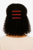 Curly natural hair styled with three red beaded Afrocentric hair clips on the back.