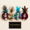 Afrocentric scrunchies with vibrant fabrics, cowrie shells, charms, and decorative feathers