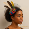 Woman wearing Afrocentric headband with colorful Ankara fabric, feathers, and mesh detail