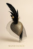 Gold glitter heart fascinator with black feathers and mesh veil on cream background