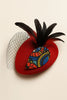 Red Afrocentric fascinator hat with black feathers, mesh veil, and colorful patterned accent