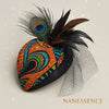 Handcrafted Afrocentric fascinator with vibrant orange, blue, and green patterns, peacock feather, black mesh.