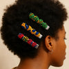 Afro-textured hair adorned with colorful Afrocentric fabric hair clips, close-up side view