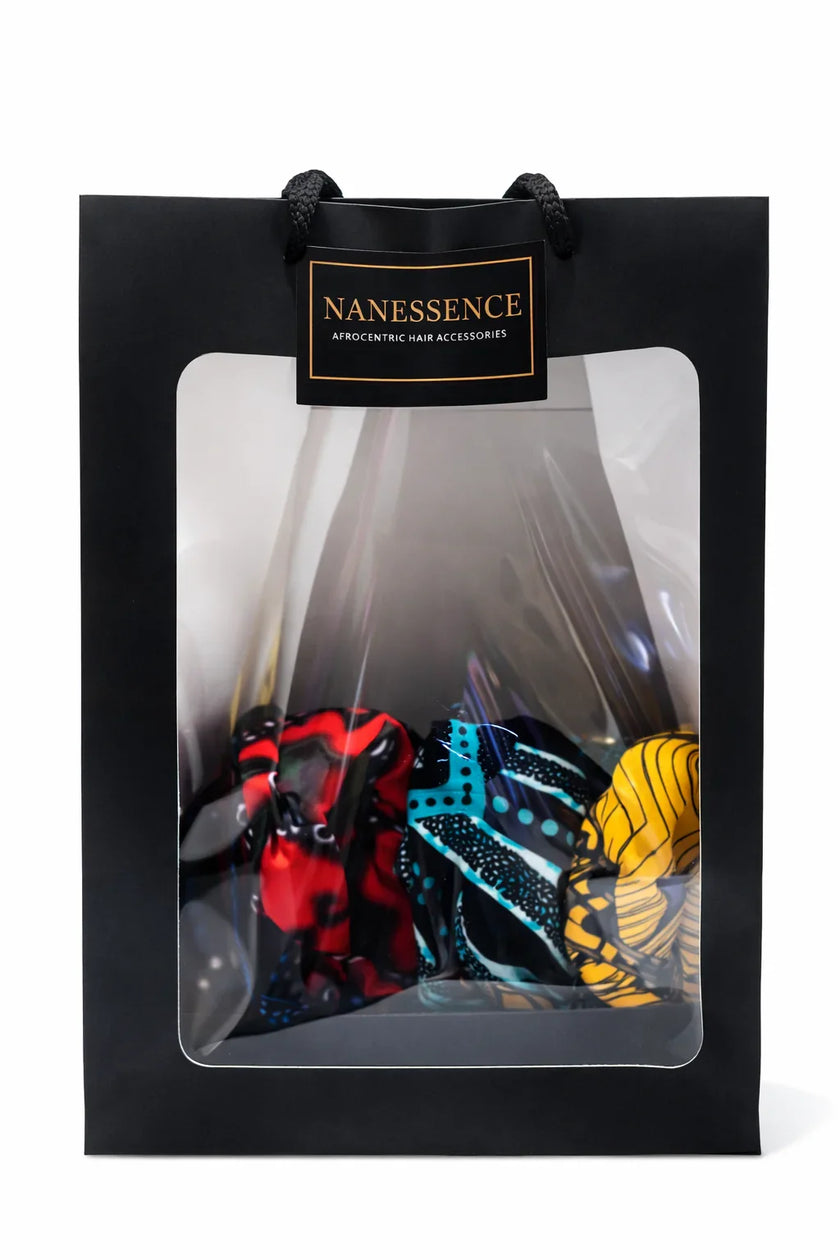 Black gift bag with transparent window displaying colorful Afrocentric hair accessories