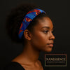 Woman wearing vibrant blue and red Afrocentric headband, natural hair, on black background
