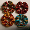 Handcrafted Afrocentric fabric scrunchies with pearls in vibrant patterns, four styles displayed.