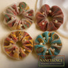 Set of four colorful Afrocentric hair scrunchies with mesh and pearl accents on satin fabric